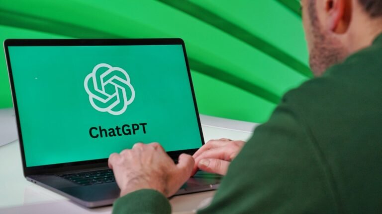 Person typing on a laptop with ChatGPT open on a green-lit screen